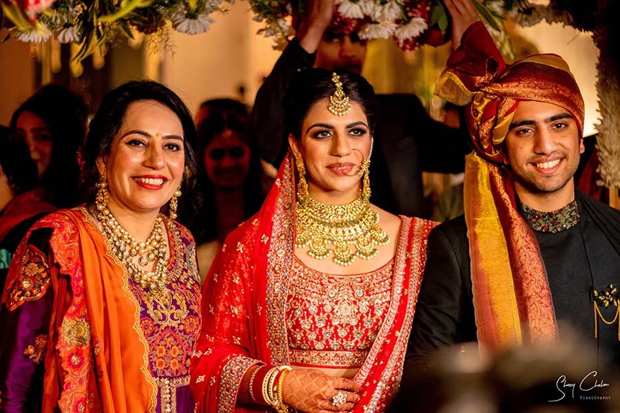 Bride and groom close together in red wedding attire